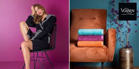 Eine Frau in einem schwarz-weißen Bademantel sitzt auf einem Stuhl vor einem rosa Hintergrund. Neben ihr liegt ein rostfarbener Stuhl mit drei Handtüchern in Blau, Orange und Lila. Neben dem Stuhl steht eine metallische Vase mit lila Blumen und einem Vossen-Logo vor einer blauen Wand.