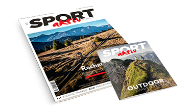 Gezeigt werden zwei Zeitschriften mit dem Titel „SPORT aktiv“. Auf den Titelseiten sind Menschen zu sehen, die auf einem Bergpfad mit dem Fahrrad unterwegs sind, mit malerischen Landschaften im Hintergrund.