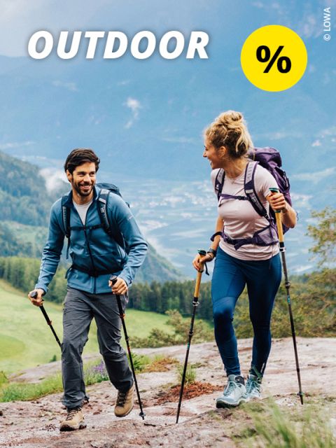 Mann wandert auf einem felsigen Bergpfad. Er trägt einen Rucksack und lässige Outdoor-Kleidung. Im Hintergrund ist eine malerische Landschaft mit Berggipfeln und strahlend blauem Himmel zu sehen. Oben sind das Wort „OUTDOOR“ und ein Prozentzeichen zu sehen.