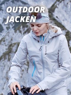 Eine Frau, die eine hellgraue Outdoor-Jacke und ein Stirnband trägt, steht im Freien in einer bergigen Gegend und stellt einen Gurt ein. Großer weißer Text: "OUTDOOR JACKEN.