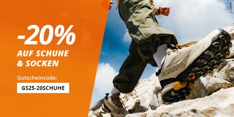 Eine Person in Wanderschuhen und Socken geht auf felsigem Gelände unter blauem Himmel. Der Text auf der linken Seite lautet: "-20% AUF SCHUHE & SOCKEN. Gutscheincode: GS25-20START".