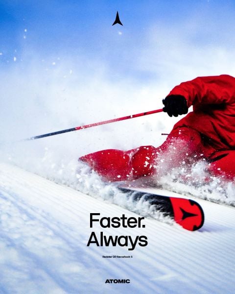 Ein Skifahrer in weiß-schwarzem Outfit rast auf Schnee bergab, aufgenommen von oben. Der deutsche Text lautet: „Auf der Rennstrecke geboren. Für die Piste gebaut.“ Ein Ausschnitt zeigt einen Skifahrer mit Skiern.