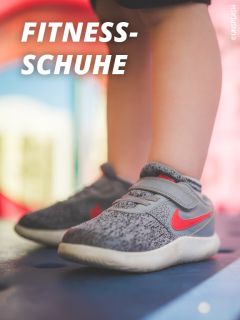 Nahaufnahme eines Kindes in grauen und roten Sportschuhen, das auf einer blauen Fläche steht, auf der oben links in fetter weißer Schrift "FITNESS-SCHUHE" steht.