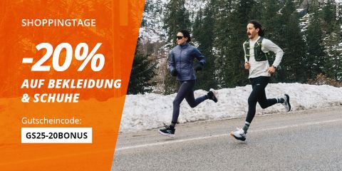 Zwei Menschen laufen im Freien auf einer Straße neben Schnee und Bäumen. Auf dem orangefarbenen Banner auf der linken Seite steht: "Shoppingtage -20% auf Bekleidung & Schuhe. Gutscheincode: GS25-15BONUS.