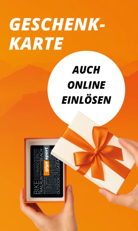 Hände halten eine geöffnete Geschenkschachtel mit orangefarbener Schleife, die eine Geschenkkarte enthüllt; der Text lautet "Geschenkkarte auch online einlösen".