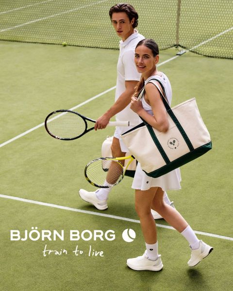 Zwei Tennisspieler in weißer Kleidung laufen mit Schlägern über einen Tennisplatz; einer trägt eine große Björn-Borg-Tasche. Der Text "BJÖRN BORG train to live" wird gezeigt.