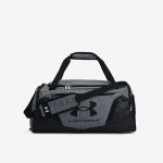 Graue und schwarze Under Armour-Reisetasche mit Tragegriffen, einem Schultergurt, Reißverschlusstaschen und dem Under Armour-Logo auf der Vorderseite.