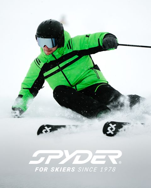 Ein Skifahrer in schwarz-gelbem Outfit fährt einen schneebedeckten Hang hinunter, im Hintergrund eine schneebedeckte Landschaft. Oben steht der Text: „SPYDER FÜR SKIFAHRER SEIT 1978.“ In der unteren rechten Ecke ist ein kleines weißes Spinnenlogo zu sehen.